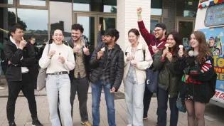 8 students outside the Nucleus Building laughing and eating icecream
