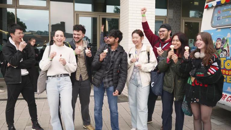 8 students outside the Nucleus Building laughing and eating icecream