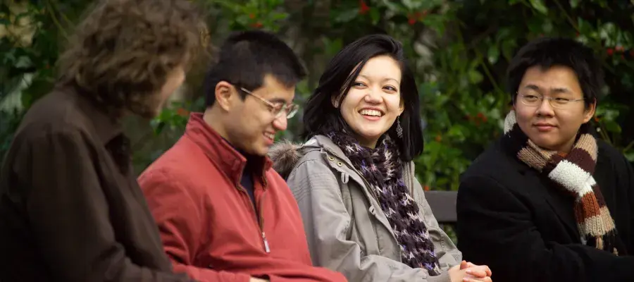 International students sitting on bench talking