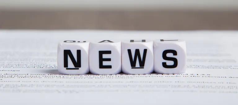Image of 4 dice with letters spelling out "NEWS"