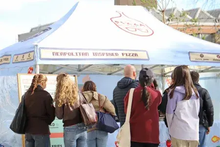 People waiting in a queue at a food van 