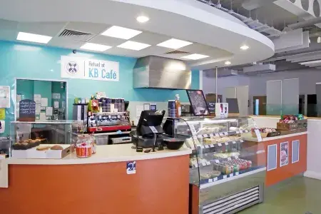 A cafe kiosk full of food and a coffee machine 