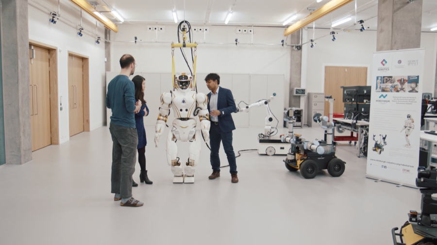 Three researchers working with the Valkyrie humanoid robot